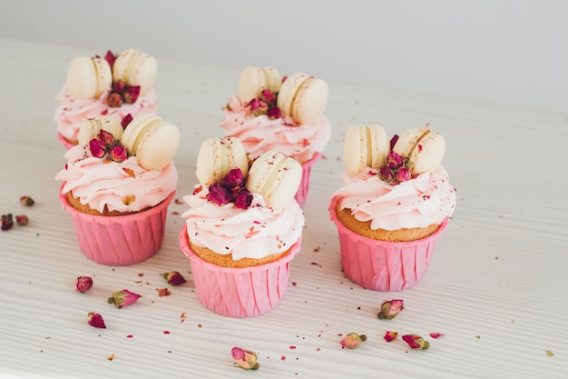 Cupcakes met roze room, bitterkoekjes en rozen