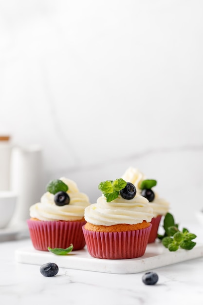 Photo cupcakes muffins decorated with cream berries and green mint leaves delicious homemade dessert