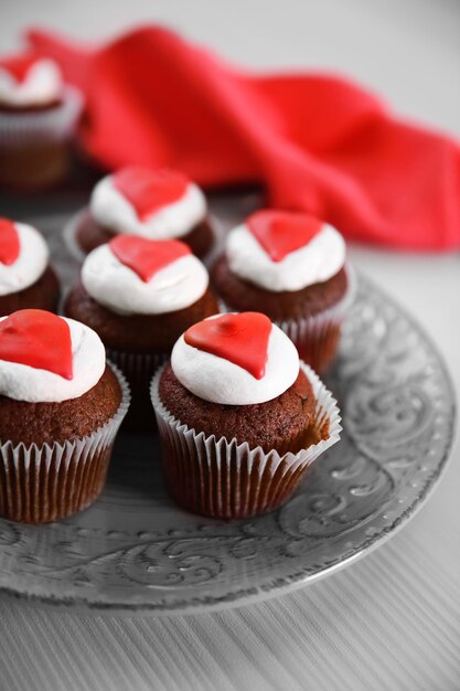 Cupcakes on plate on a light wooden background