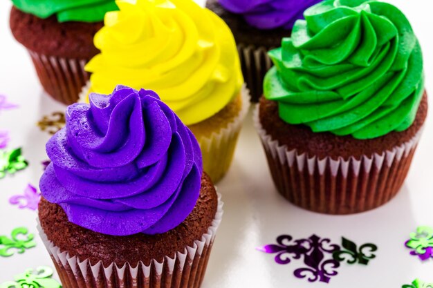 Cupcakes versierd met felgekleurde glazuur voor Mardi Gras-feest.