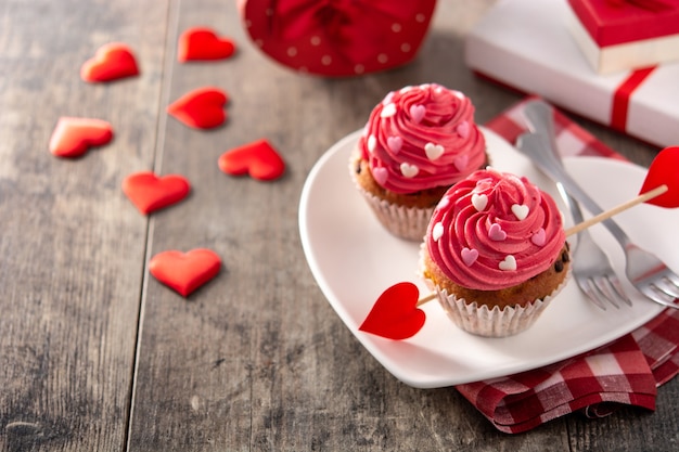 Cupcakes versierd met suikerharten voor valentijnsdag op houten tafel