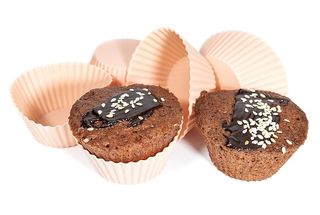 Cupcakes with chocolate icing and baking dishes on a white background Cakes and sweet pastries