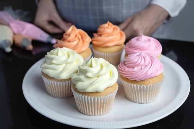 Cupcakes with color cream on a plate.