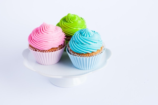 Cupcakes with cream cheese on the cake stand on white