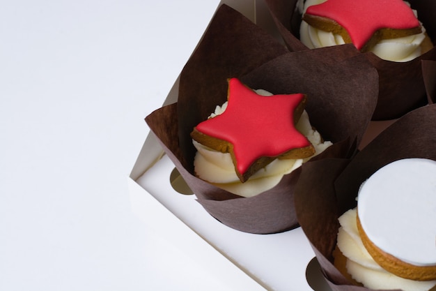 Cupcakes with cream and red stars on a white background.