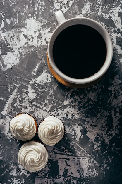 Cupcakes with cups of coffee.