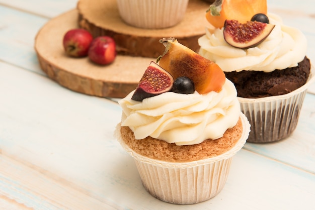 Cupcakes with Fig, persimmon and cream cheese on a wooden table