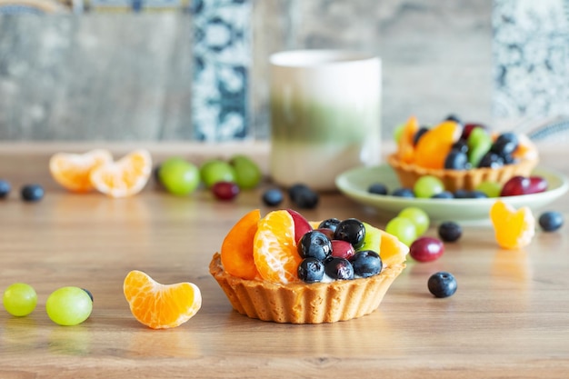 cupcakes with fruits on wooden table on kitchen