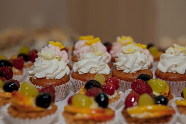 Cupcakes with raspberries grapes and peach on a wedding table
