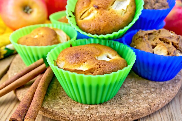 Cupcaketarwe en rogge met appels in siliconevormen, kaneel, servet op een houten plankenachtergrond