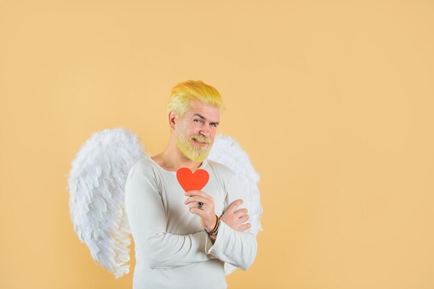 キューピッドは、バレンタインの心のハンサムな天使のキューピッドの愛の概念のバレンタインの天使のひげを生やした男を保持します