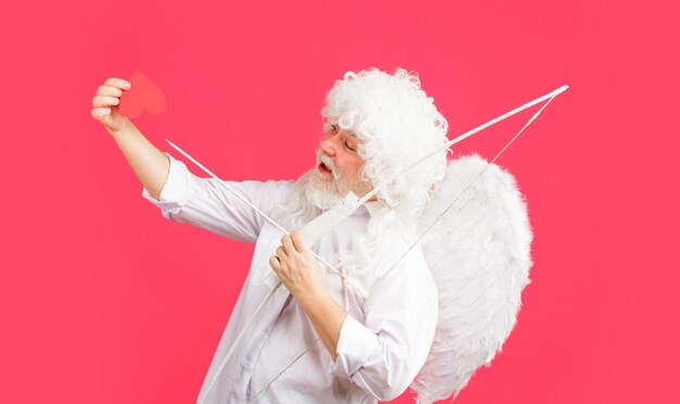 Foto cupido a san valentino con cuore di carta rossa angelo maschio con arco e frecce frecce d'amore