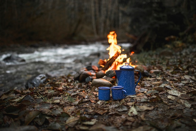 Cups and bonfire near stream