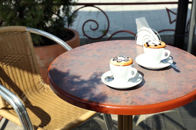 Cups of cappuccino on table in cafe outdoors