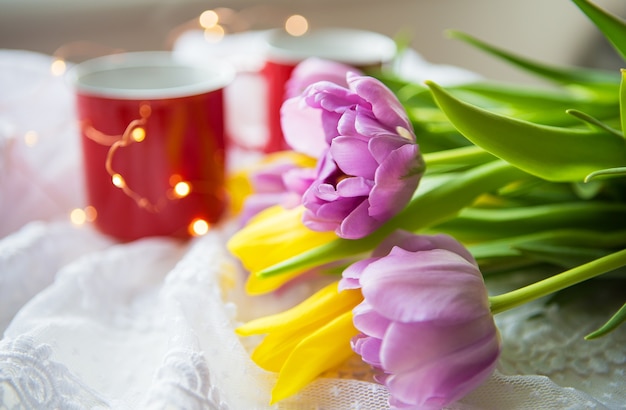 Cups of coffee and bouquet tulips