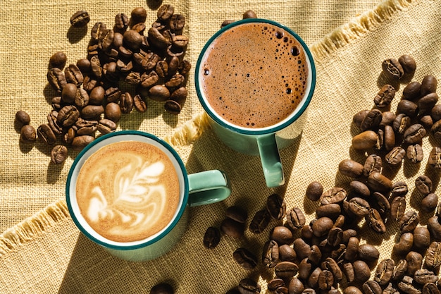 Cups of coffee and coffee beans,illuminated by sunlight , autumn day.