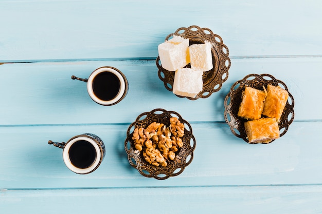 Tazze di caffè vicino a piattini con dolci dessert turchi