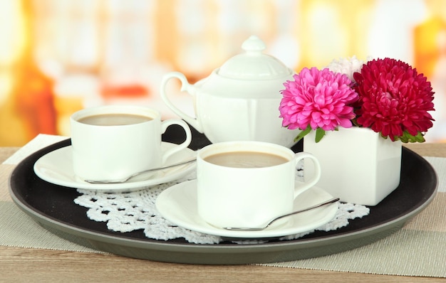 Cups of coffee on tray on table in cafe