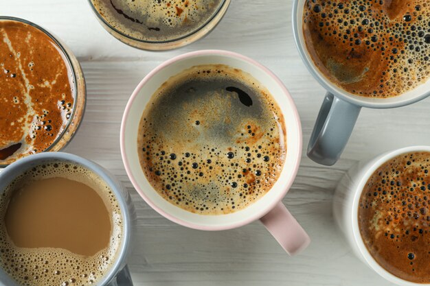 Cups of coffee on white wooden