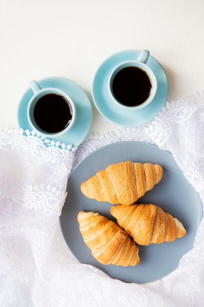 Cups of coffee with croissants