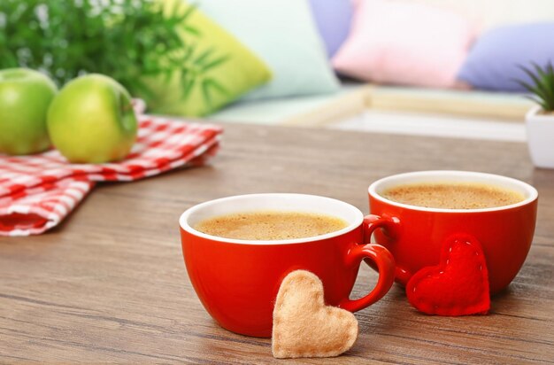 Чашки кофе с сердцем на деревянном столе