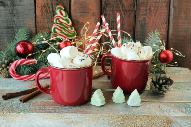 Cups of coffee with meringues and marshmallows spruce branches Christmas decorations