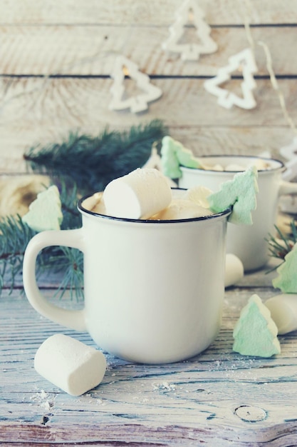 Cups of coffee with meringues and marshmallows spruce branches illumination Christmas New Year