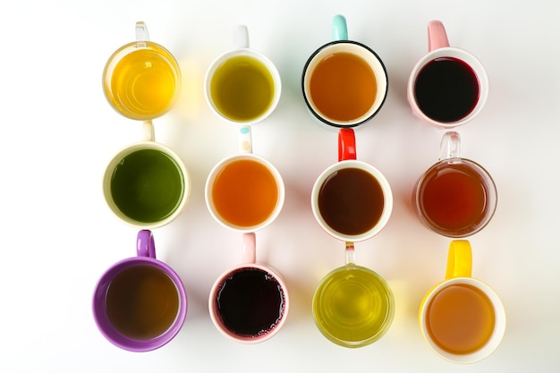 Cups of different tea on white background