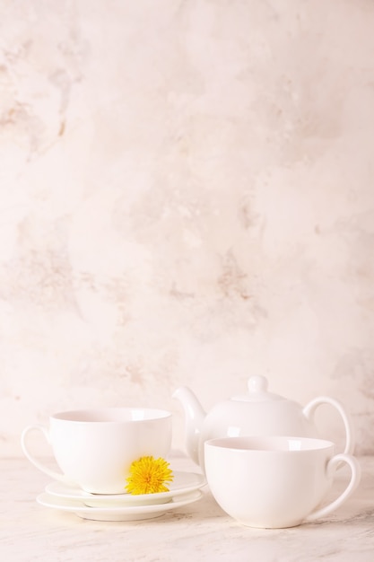 Cups of healthy dandelion tea on light