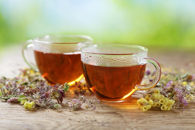 Cups of herbal tea with dried herbs