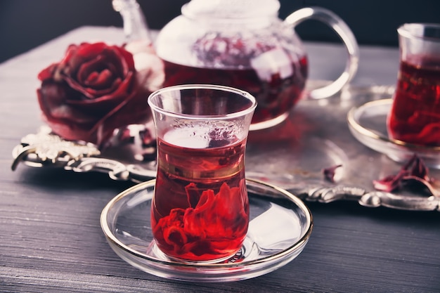 Cups of hot red karkade tea with teapot on the tray