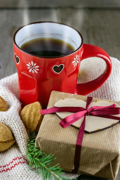 Cups of hot tea with cookies and Christmas gift box on table