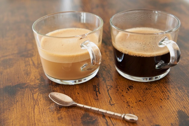 Cups of latte and black coffee with Nespresso capsules