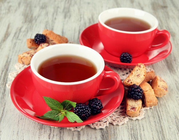 テーブルクローズアップでクッキーとブラックベリーでお茶を飲む