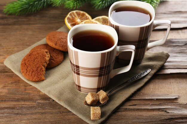 Cups of tea with cookies on table close-up