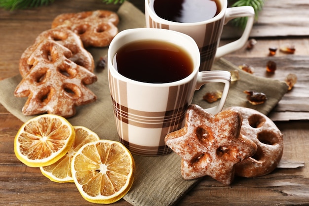 Cups of tea with cookies on table close-up