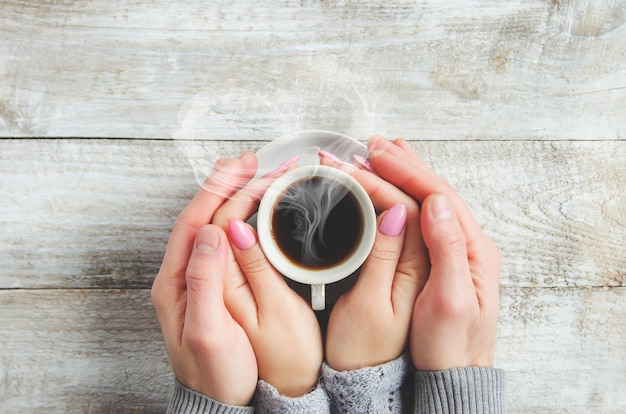 Cups with a coffee in the hands of men and women. Selective focus.