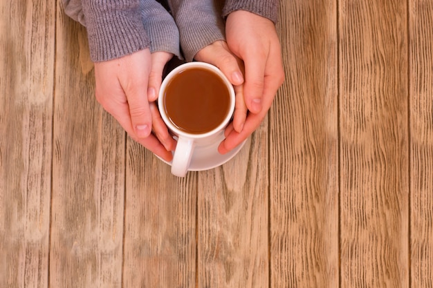 Cups with a coffee in the hands of men and women.