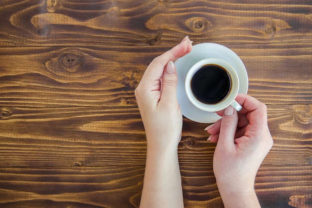 Cups with a coffee in the hands of men and women.