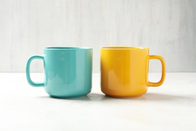 Cups with drinks in Ukrainian flag colors on white textured table