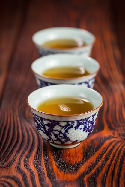 Cups with green tea on wood