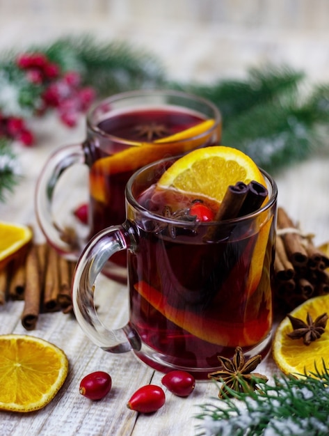 Cups with hot mulled wine on a wooden background. New year concept