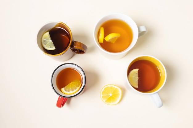 Cups with tea with lemon on a beige background.