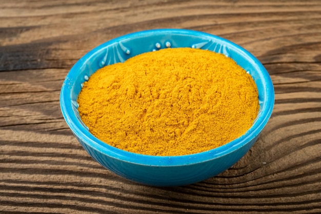 Curcuma powder in a small bowl on the table