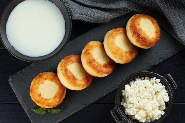 Curd fritters with milk and cottage cheese Food photo in a dark tone