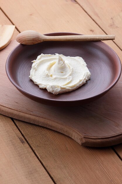 Curd mass on a clay plate on a wooden board Still life on a wooden background Closeup