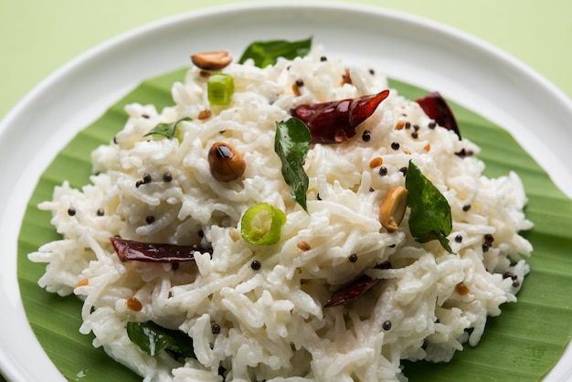 Curd Rice or Dahi Bhat OR Chawal with curry leaf, peanuts and chilli- Served in a bowl over moody background. Selective focus