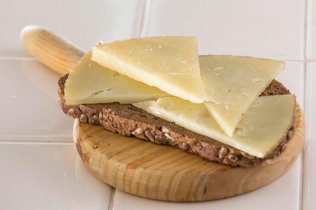 Cured cheese toast on wooden board in kitchen