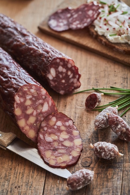 Cured sausages on wooden table