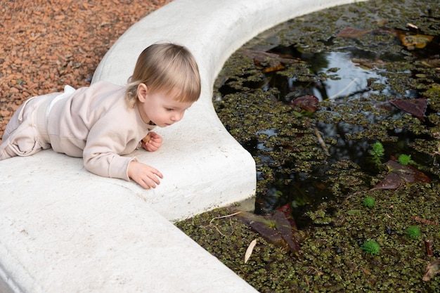 Foto bambino curioso che guarda lo stagno